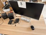un écran d'ordinateur posé sur un bureau avec un clavier et une souris
