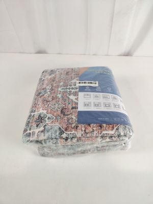 une couverture emballée dans du plastique, posée sur une surface blanche