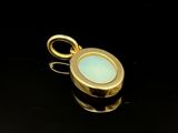 a close up of a gold plated pendant with a blue stone