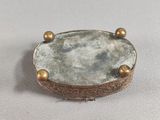 an image of a silver and gold broochle on a white surface