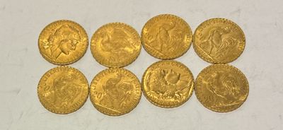 a group of six gold coins sitting on top of a white surface