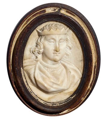 un gros plan sur un médaillon sculpté représentant un homme coiffé d'une couronne