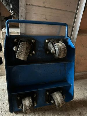 un chariot bleu muni de roues, garé devant un immeuble