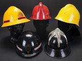 three firemen helmets are lined up on a black surface