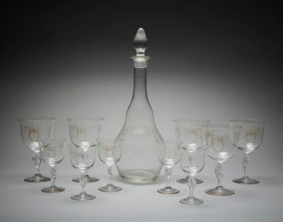 six verres à vin et une carafe posés sur une table