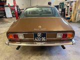 a brown car parked in a garage with a license plate on it