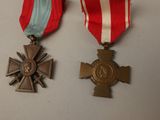 two medals and a cross on a white table