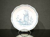 a blue and white plate with a picture of a man and a dog on it