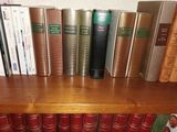 de nombreux livres qui se trouvent sur une étagère dans la pièce
