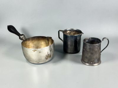 three silver cups and a silver jug on a white surface
