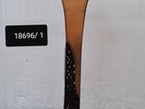 un grand vase en verre posé sur un socle en métal