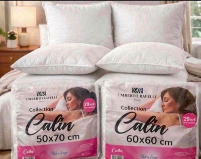 two pillows on top of each other on a bed in a bedroom
