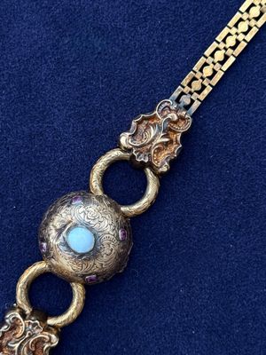 a close up of a gold bracelet with a turquoise stone on it