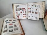 two open books sitting on a table with stamps on them