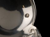 a close up of a silver vase with a black background