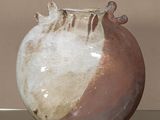 un vase marron et blanc posé sur une table en verre