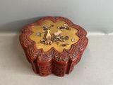 une petite boîte rouge ornée d'un motif doré