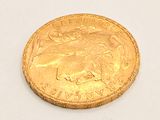a close up of a gold coin on a white surface