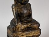 une photo représentant une statue d'une personne assise sur une caisse