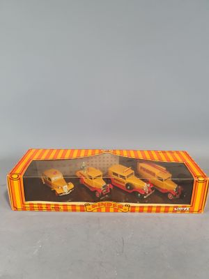 an orange and yellow box with three toy trucks in it