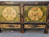 deux armoires en bois ornées de motifs peints, posées à même le sol