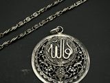 une photo d'un collier en argent orné d'un monogramme
