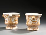une paire de vases ornés de motifs dorés et blancs sur un fond gris