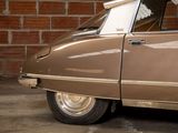 a brown car with a surfboard on top of it