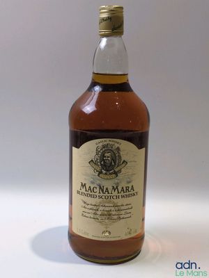 gros plan d'une bouteille de whisky sur une surface blanche
