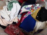a basket full of clothes that is sitting on a bed