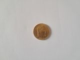 a close up of a gold coin on a white surface