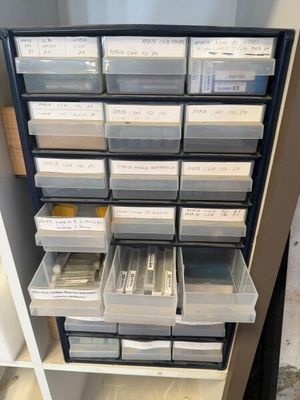 une étagère sur laquelle sont disposés de nombreux bacs contenant de petits objets