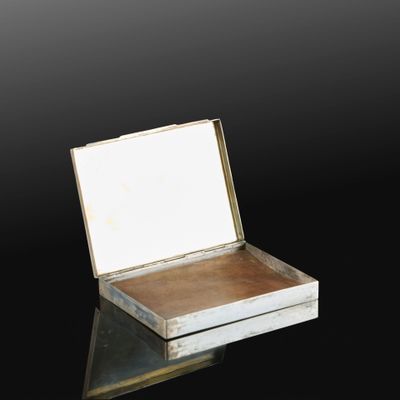 une vieille boîte en argent posée sur une surface noire