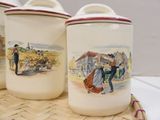 three canisters with pictures of people on them on a table