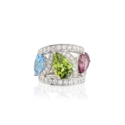 un gros plan d'une bague ornée de trois pierres de couleurs différentes