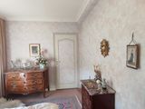une chambre avec un lit, une commode, un miroir et un tapis