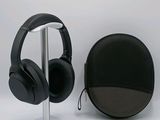 a pair of headphones sitting on a stand next to a bag