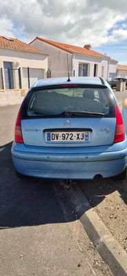 une petite voiture bleue garée sur le bord de la route