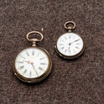 deux horloges posées sur une surface marron