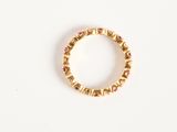 a close up of a gold ring with pink stones on a white surface