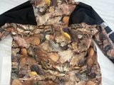 the jacket is on the bed with leaves all over it
