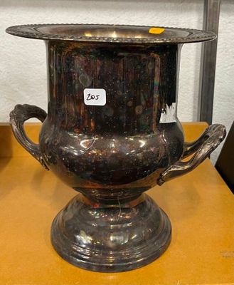 un vase en argent posé sur une table, avec une étiquette de prix dessus