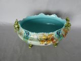 a blue bowl with flowers on it sitting on a table