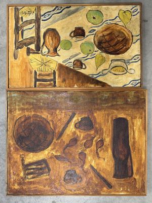 deux tableaux accrochés au mur d'une cuisine où se trouvent une table et une chaise