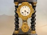 a black and gold clock sitting on top of a table