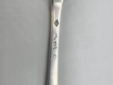 a silver spoon with writing on it sitting on a table
