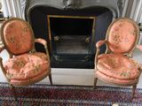 two chairs that are sitting in front of a fire place