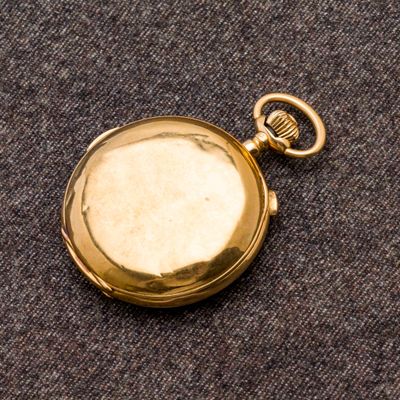 une montre de poche en or contenant une clé