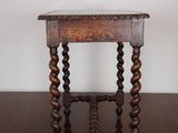 an old wooden table with a marble top on a wooden floor