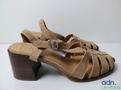 a close up of a pair of women ' s sandals on a white surface